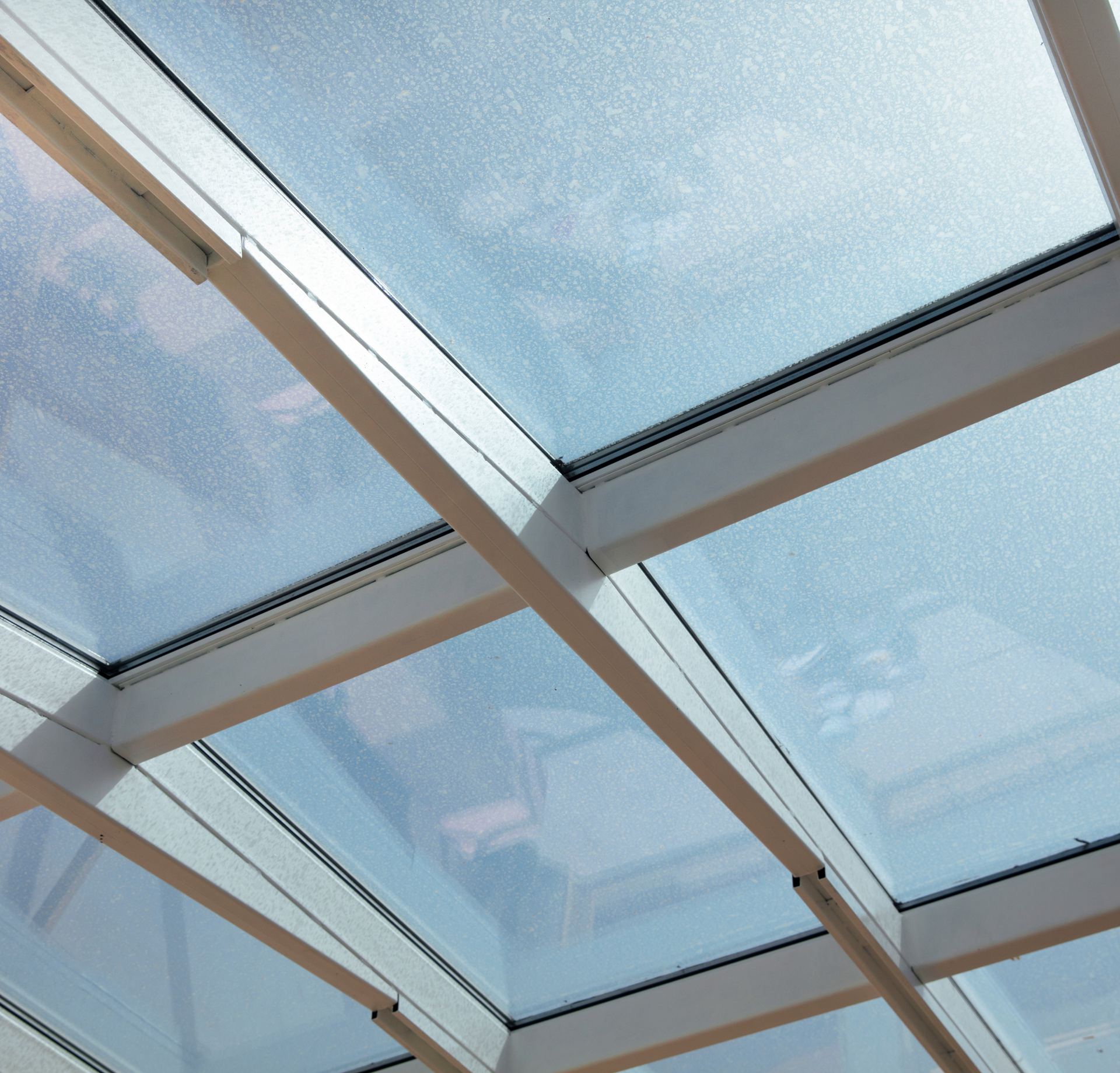 A ceiling with a lot of glass and white beams