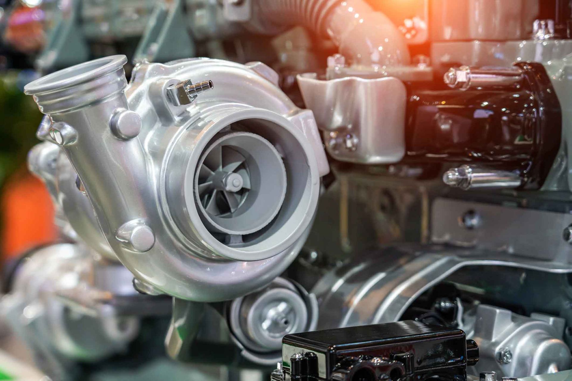 A close up of a turbocharger on a car engine.