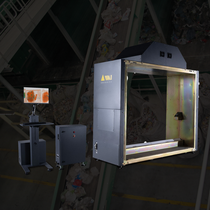 Industrial machine with open chamber and attached control unit in a dim warehouse setting