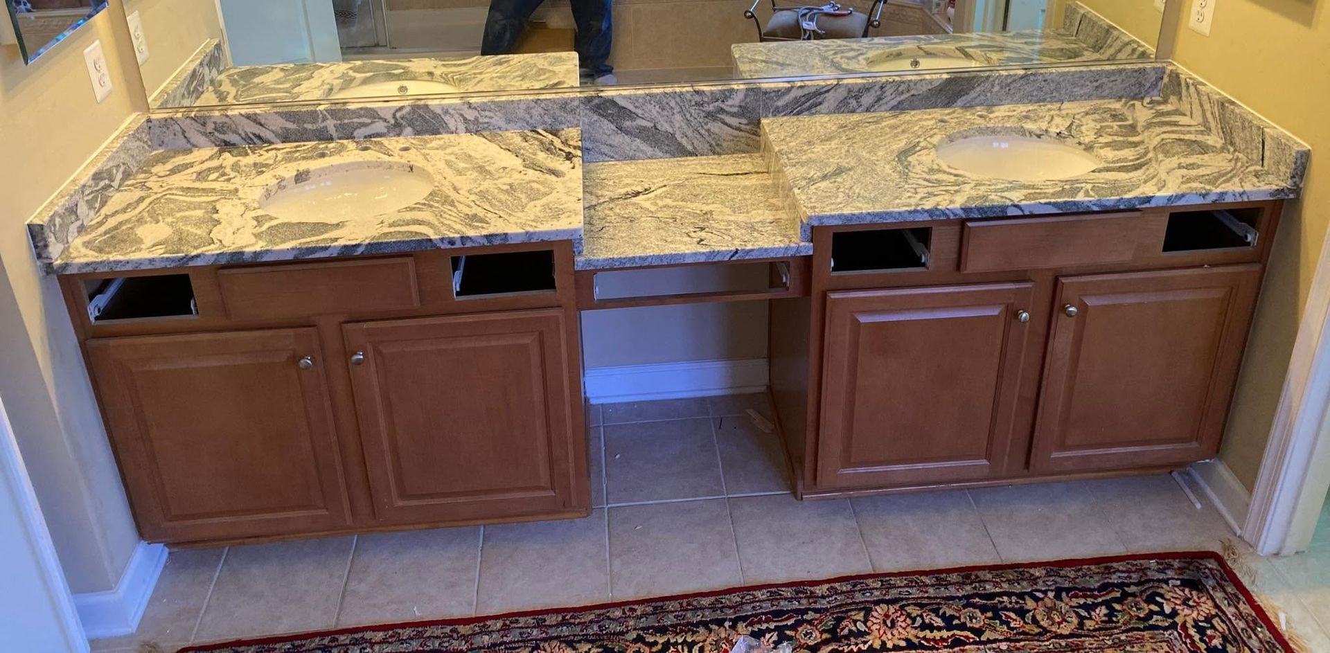 Kitchen counter with brown cabinets, granite countertop, and missing sink section
