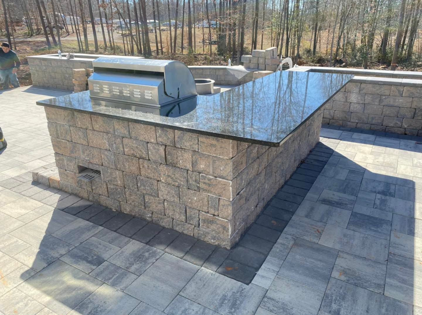 Stone memorial pedestal with a polished black top and metal plaque in an outdoor plaza