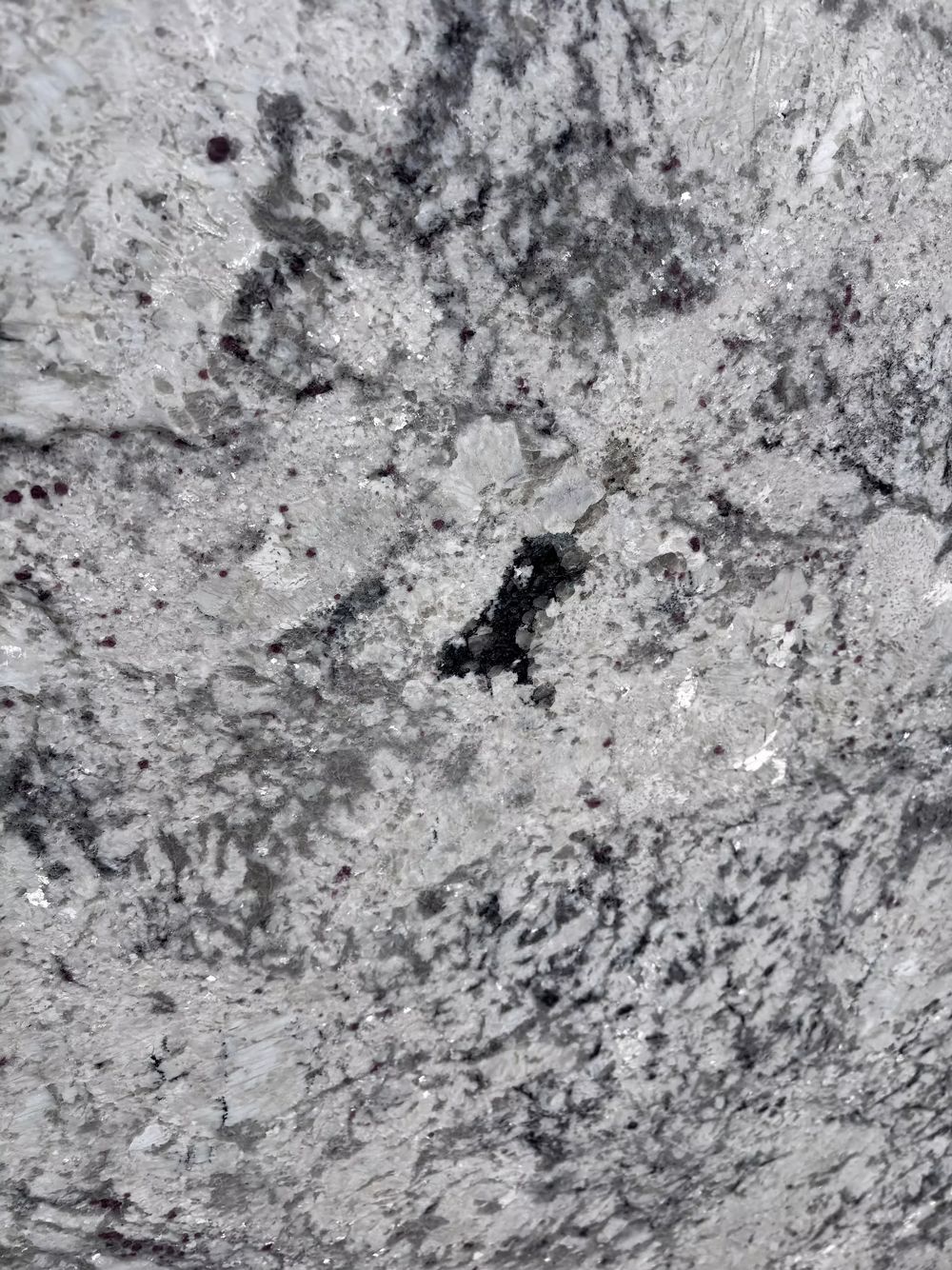 Close-up of a gray speckled granite surface with a dark crack in the center