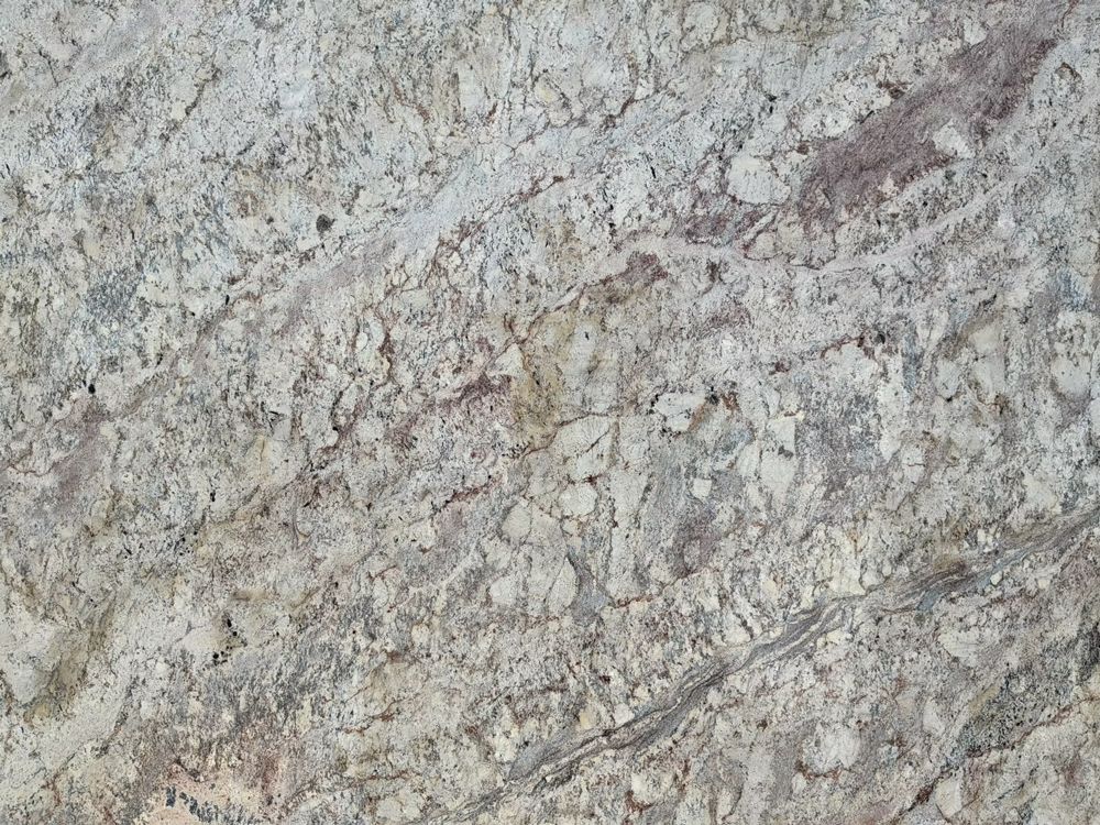 Close-up of a gray and beige speckled stone surface with faint cracks and veins