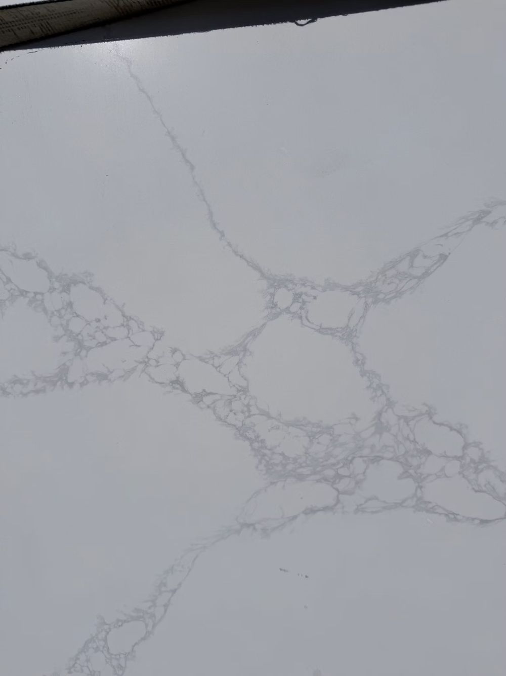 White marble countertop with gray veining and a dark edge at the top