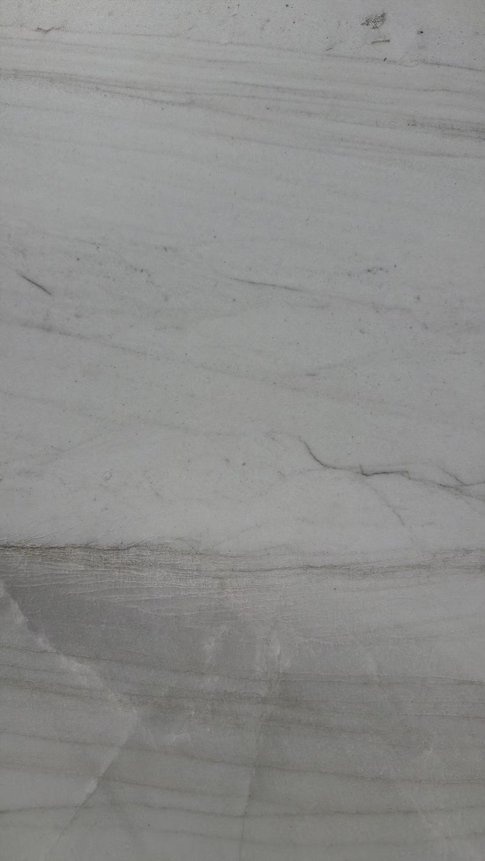 Close-up of a light gray marble surface with subtle veins and streaks.