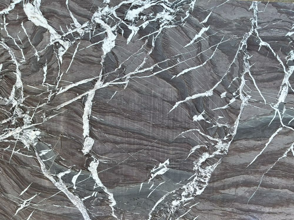 Dark gray marble surface with white veining and cracks