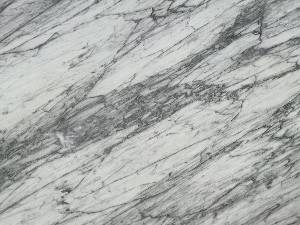 White marble surface with gray veining and diagonal streaks