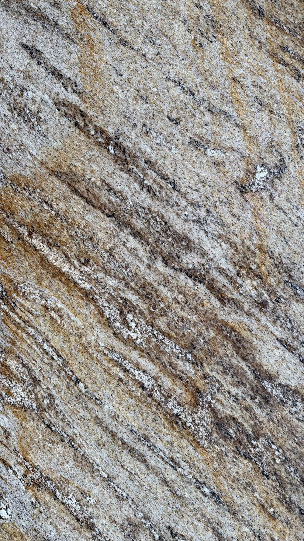 Close-up of a textured stone surface with diagonal tan, gray, and brown streaks