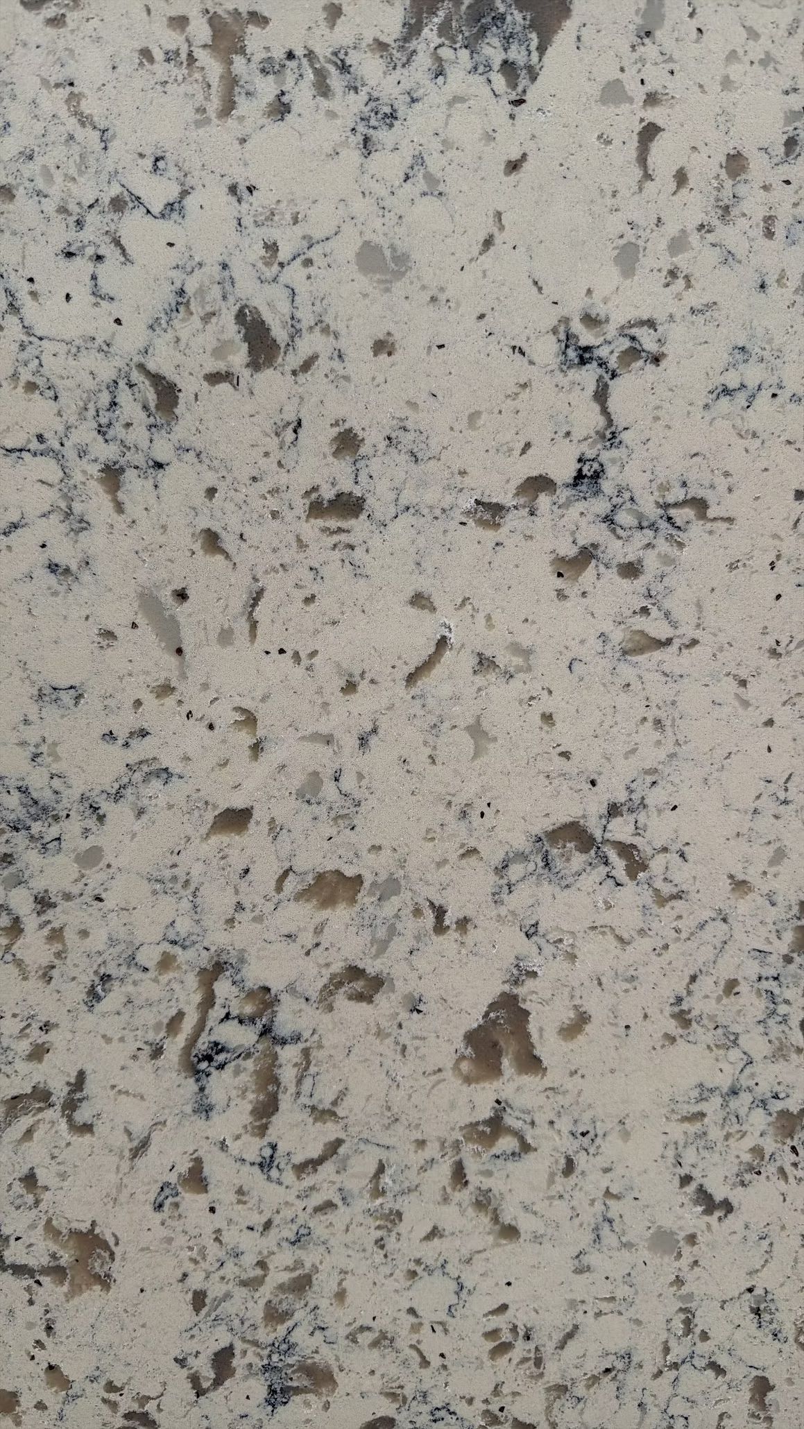 Light beige speckled stone or granite surface with dark flecks