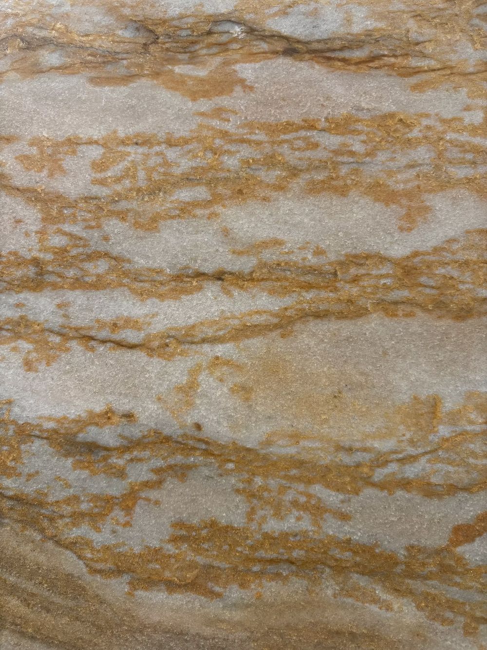 Beige and white marbled stone texture with wavy brown veining