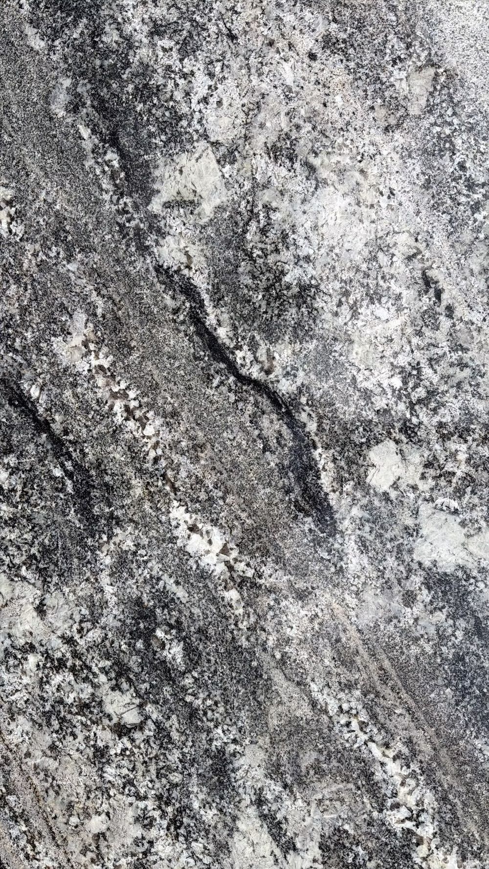 Close-up of a gray and white rough stone surface with a dark diagonal crack