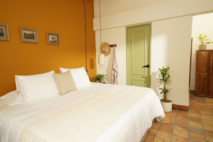 A bedroom with a large bed and a green door.