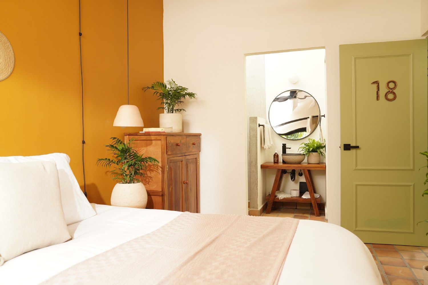 A bedroom with a bed and a green door with the number 18 on it.