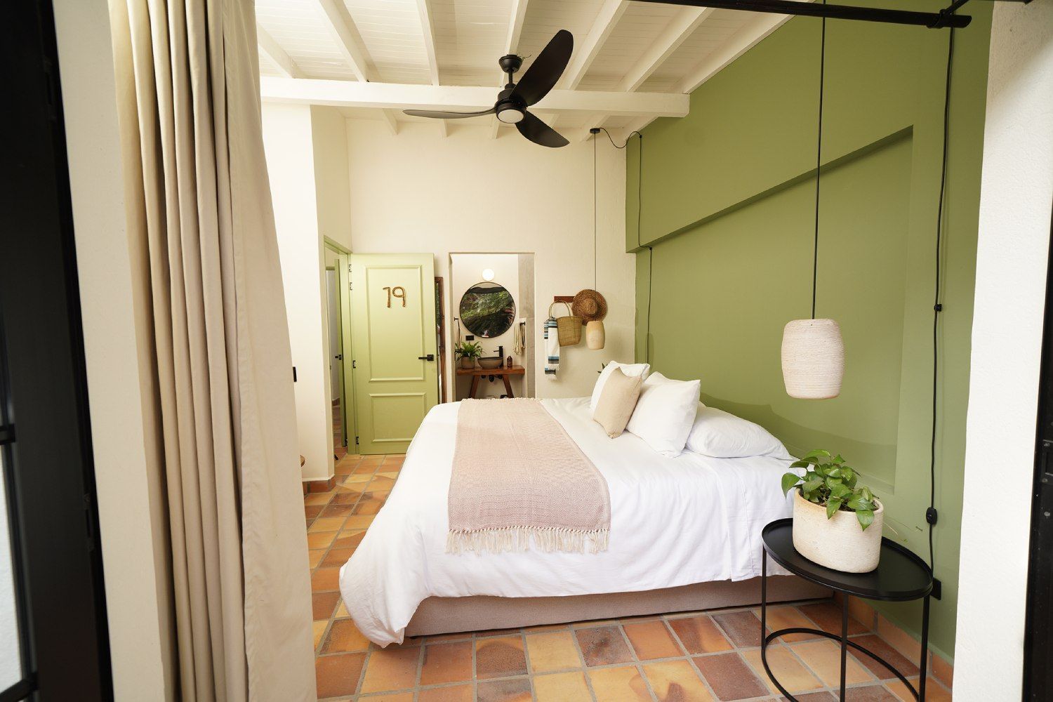 A bedroom with a bed and a ceiling fan.