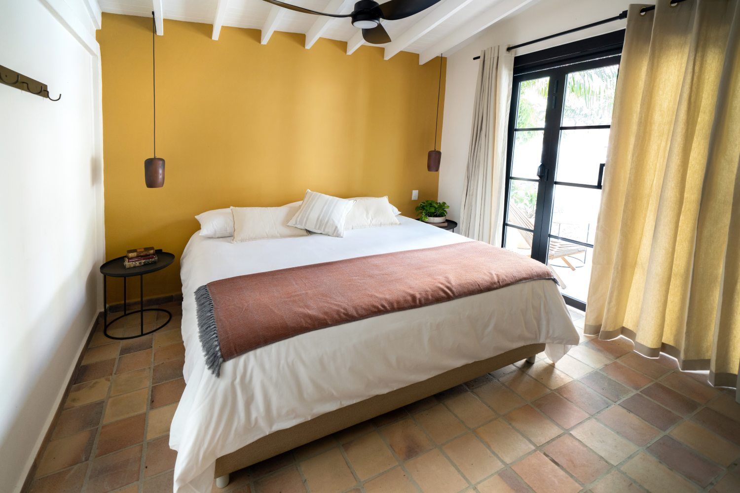 A bedroom with a large bed and a ceiling fan.
