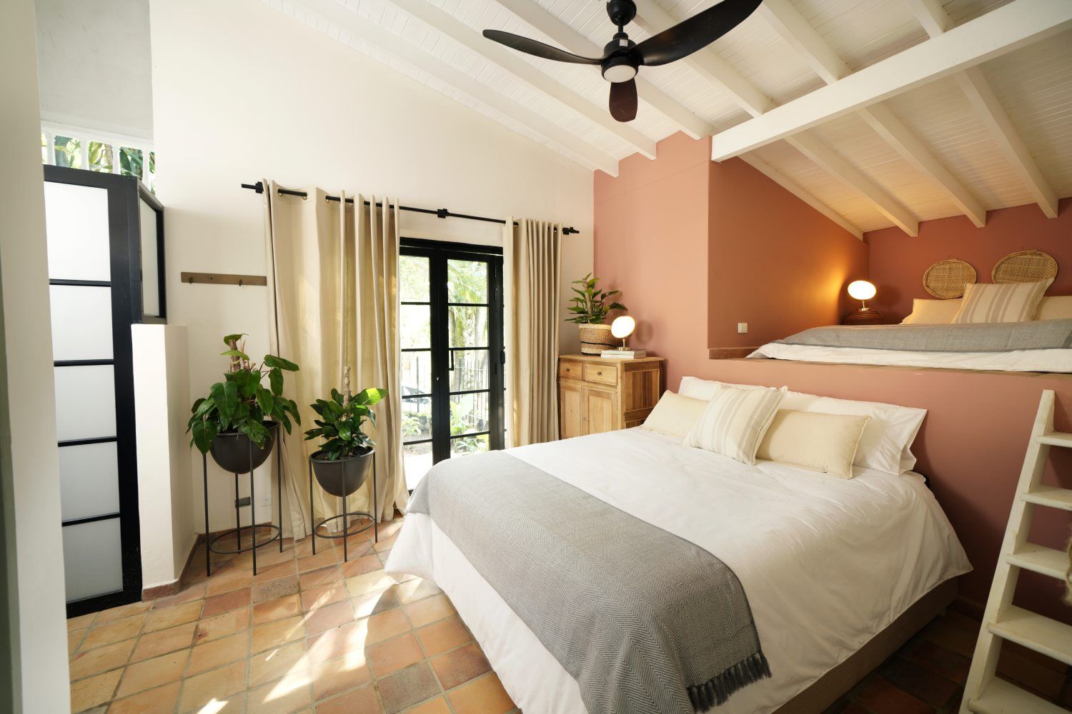 A bedroom with a bed and a ceiling fan