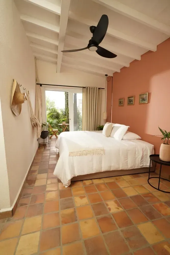 A bedroom with a large bed and a ceiling fan.