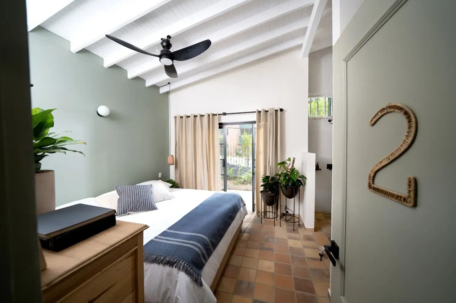 A bedroom with a bed , dresser , and window.