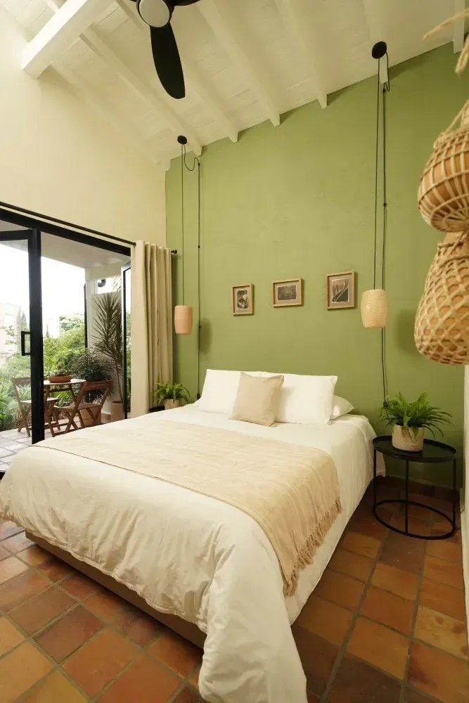 A bedroom with a bed and a balcony with a table and chairs