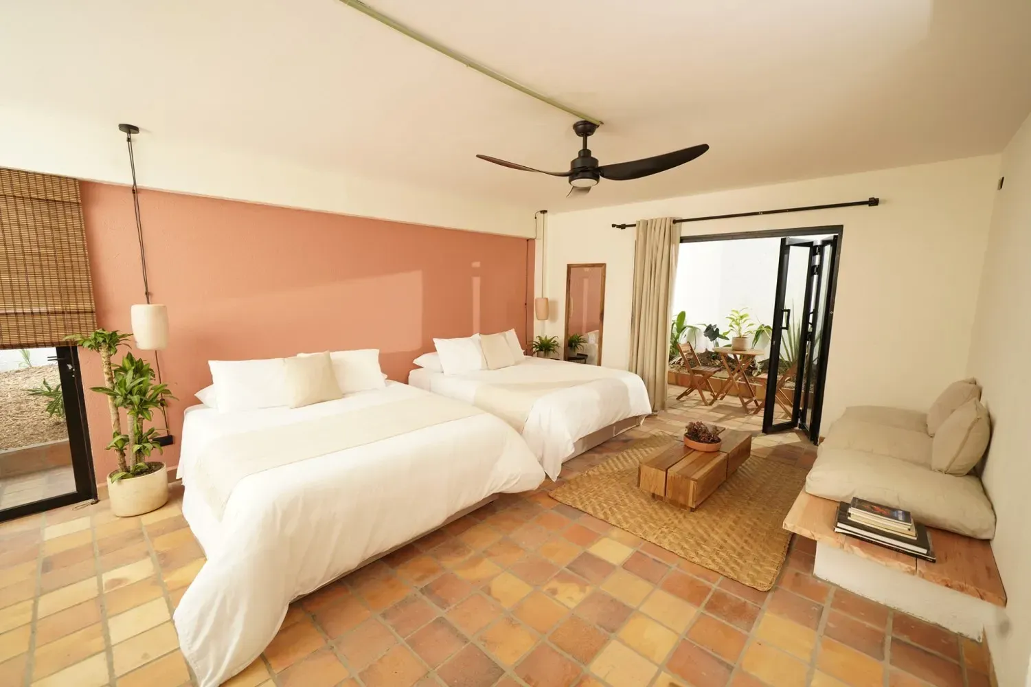 A hotel room with two beds and a couch.