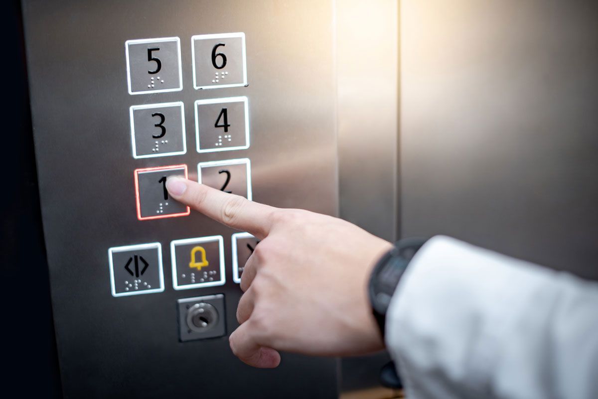 A person is pressing a button in an elevator.