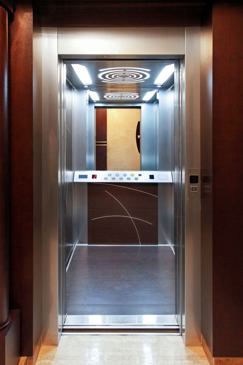 A stainless steel elevator with a wooden floor