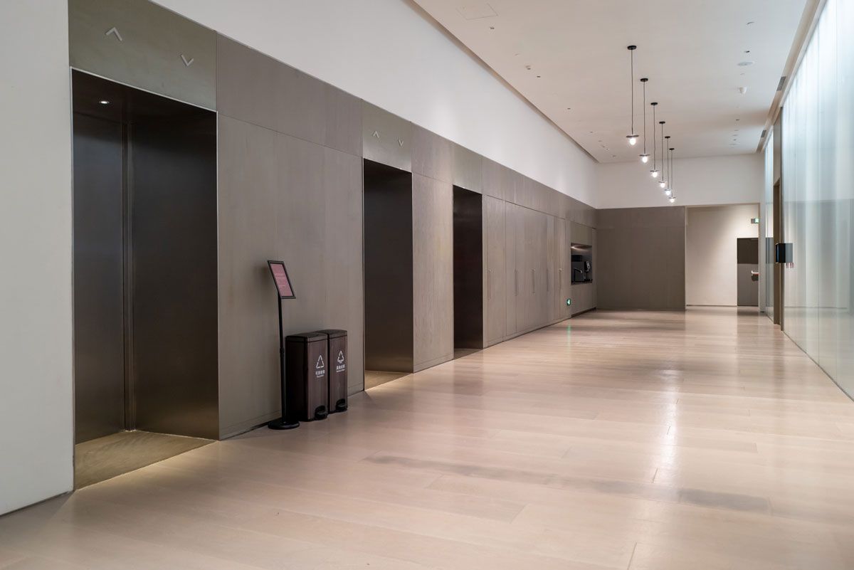 A long hallway with elevators in a building.