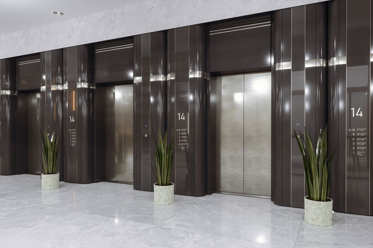 A row of elevators in a building with potted plants in front of them.
