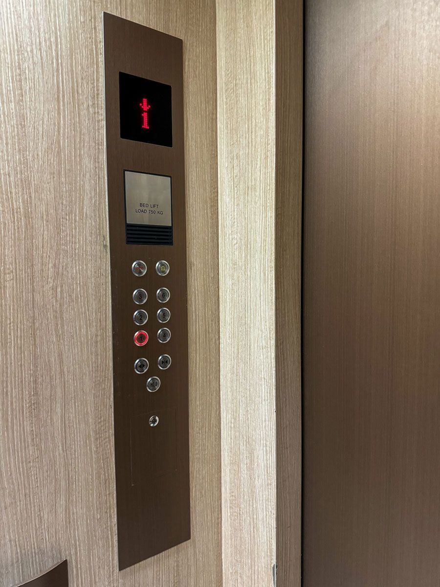 A close up of a elevator control panel on a wall.