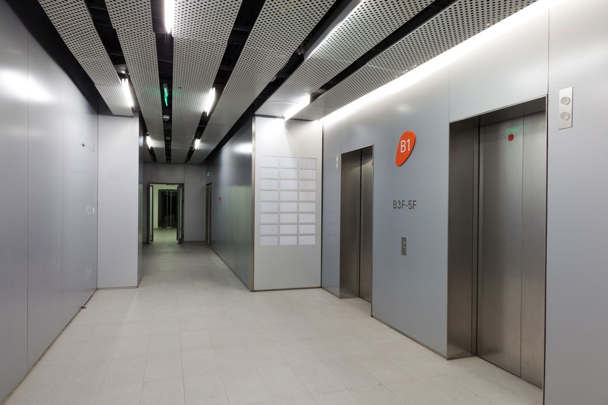 A long hallway with two elevators in it