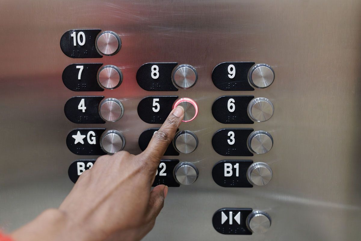 A person is pressing a button on an elevator.