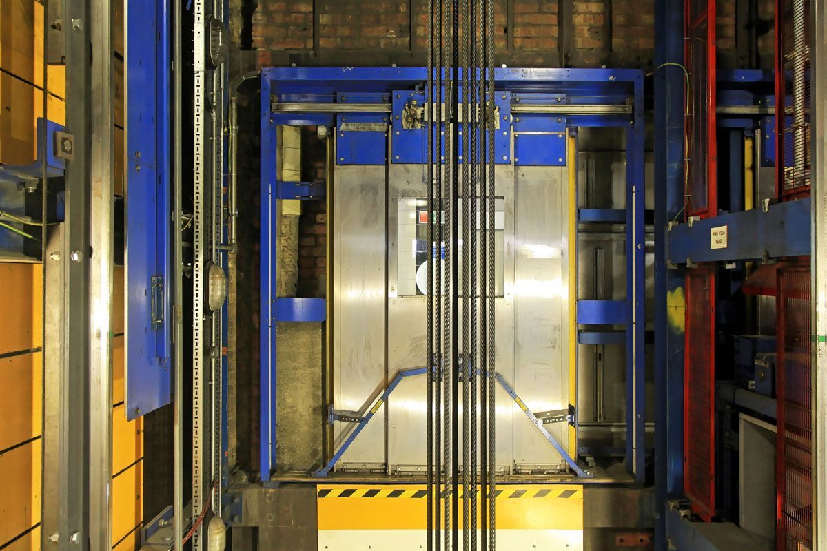The inside of an elevator with a blue door.