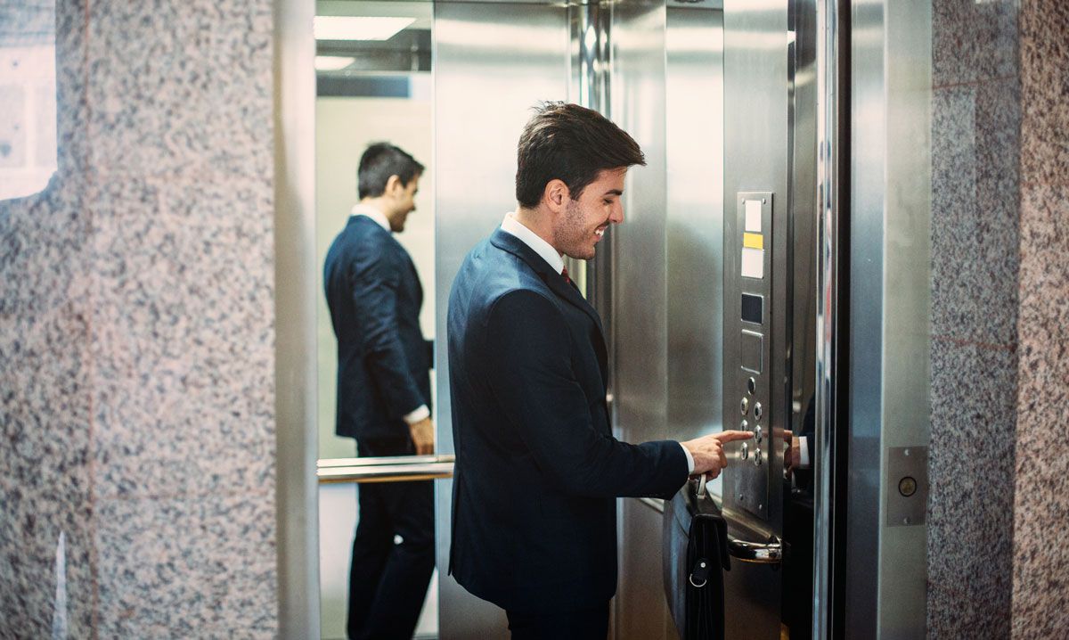 A man in a suit is getting out of an elevator.