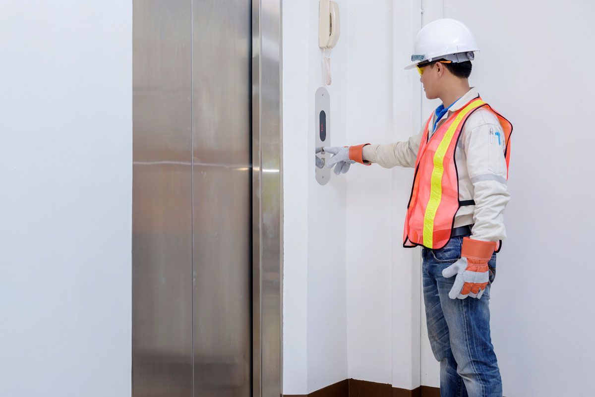 A man is pressing a button on an elevator.
