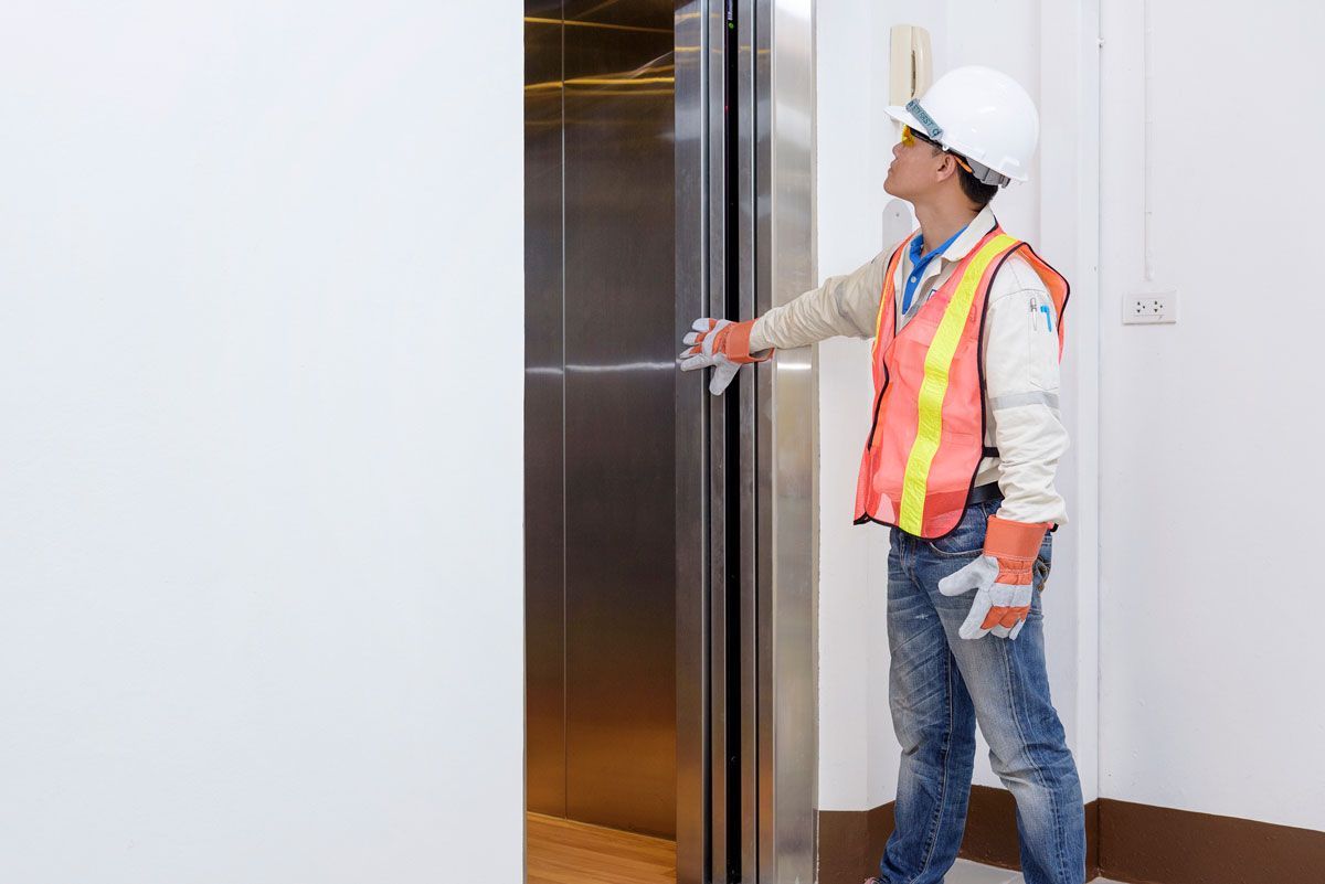 A man is standing in front of an elevator door.
