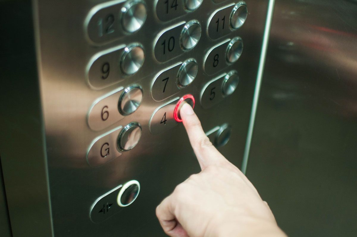 A person is pressing a button in an elevator.