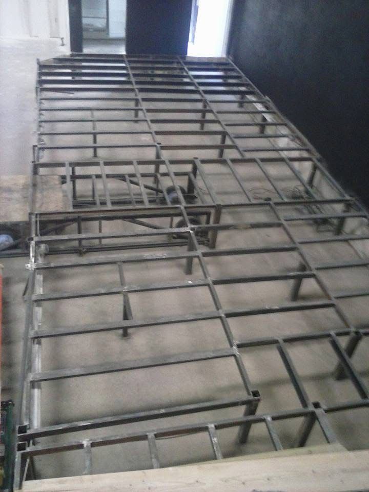 Metal bunk bed frame viewed from below in a small room, with a window above.