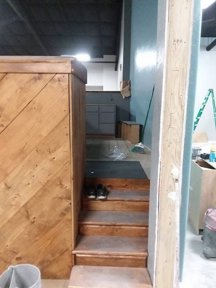 Narrow indoor stairway with a pair of shoes on a step, leading to a dim storage area.