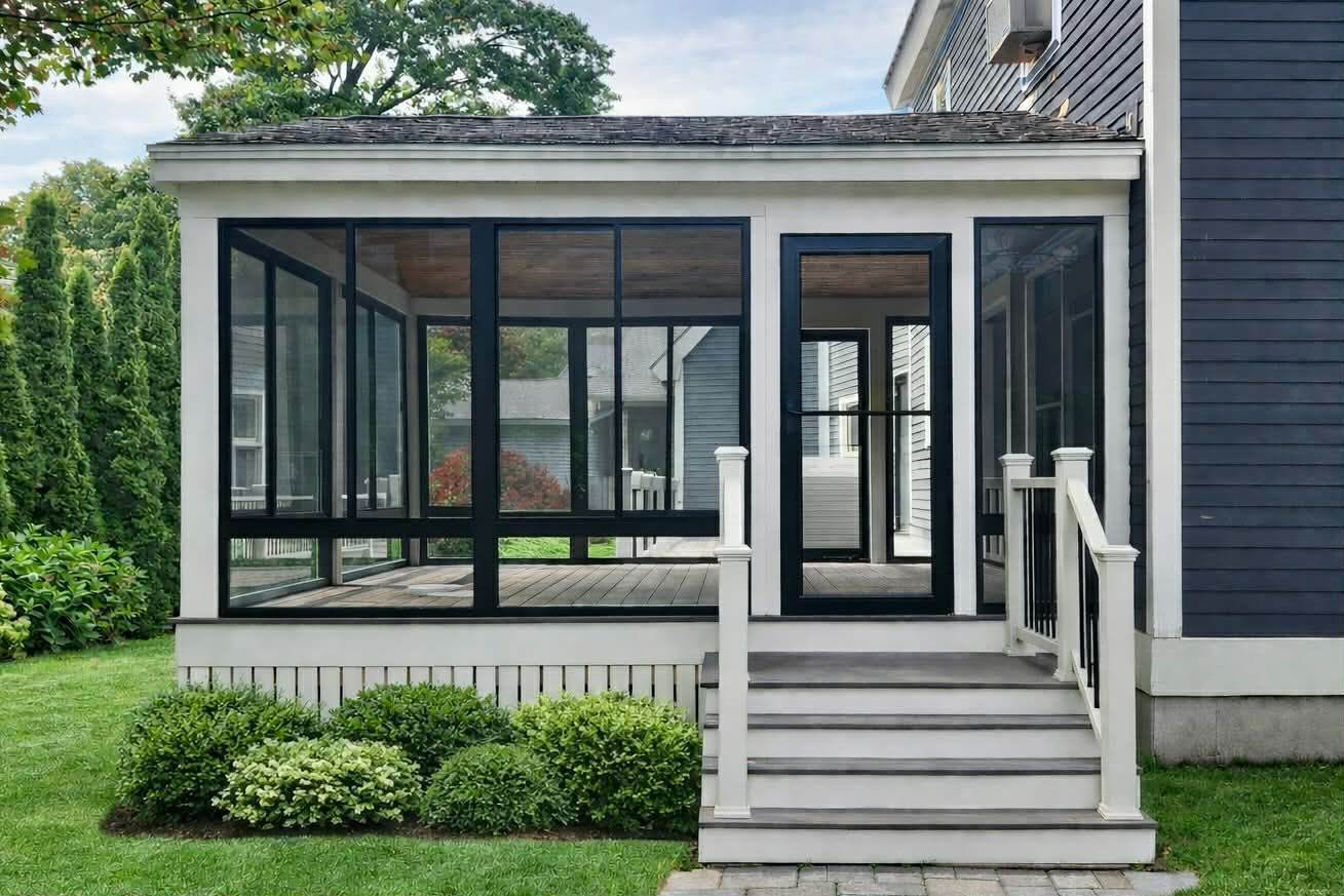Modern front porch with glass-enclosed sunroom, front steps, and white railing on a house exterior.