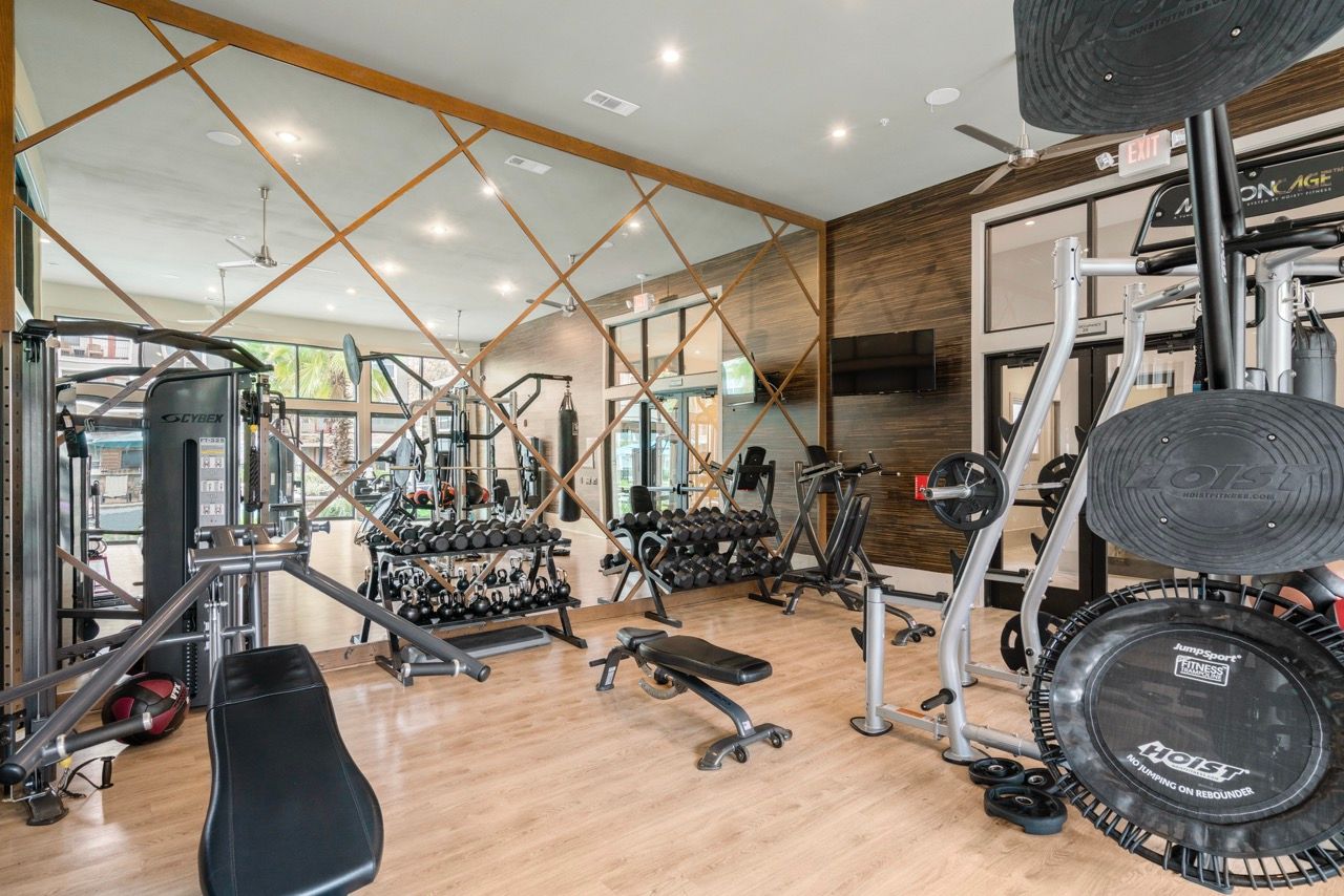 Bright fitness center with free weights, machines, and benches in a modern workout space.