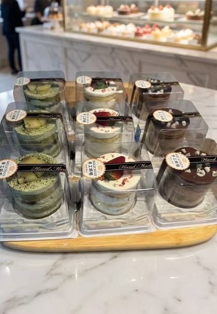 Green rolled cake with red bean filling beside a steaming latte on a dark slate board