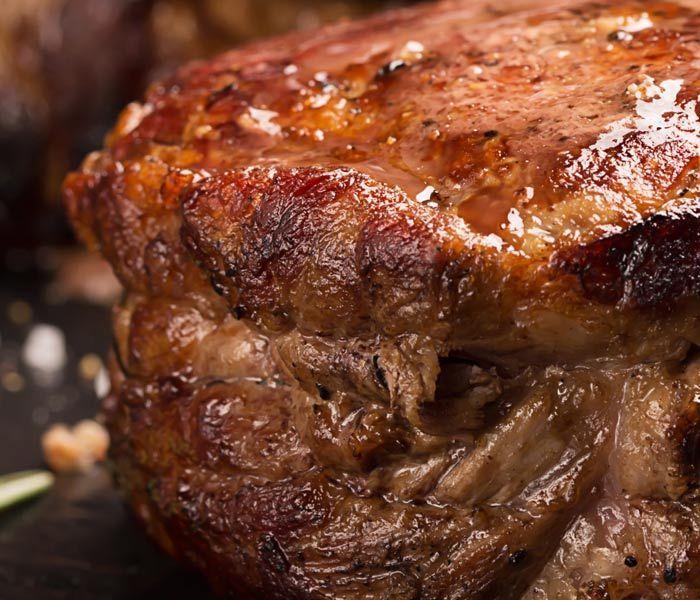 Close-up of a seared, juicy steak with a browned crust and glistening surface