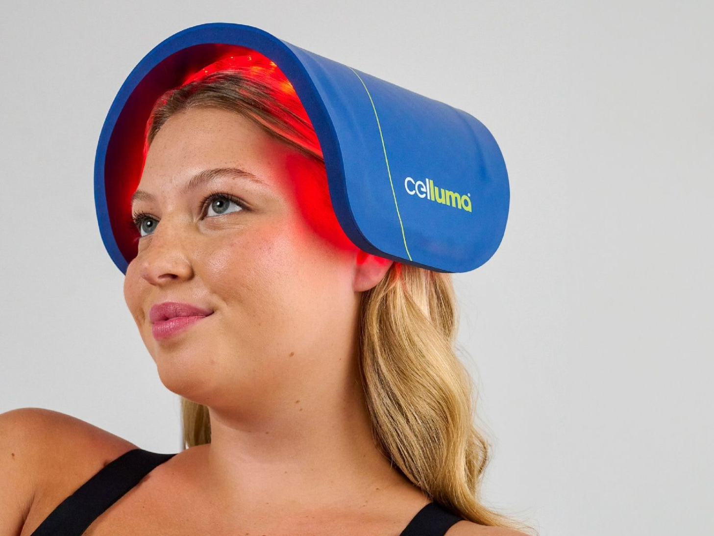 Woman wearing the CellumaNOVA red light therapy panel on her head for hair growth