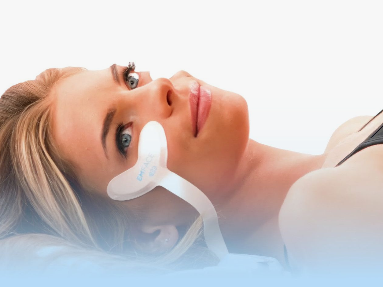 Woman lying down with a white under-eye mask, resting on a light background