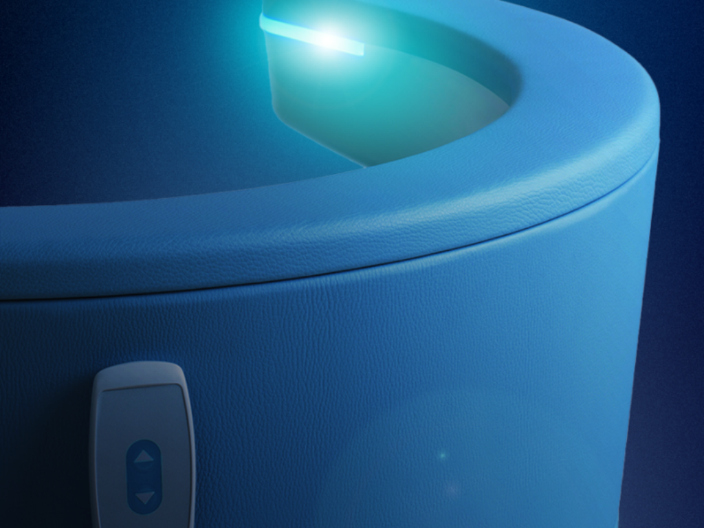 Close-up of a blue cylindrical device with a glowing top light and a small front button.