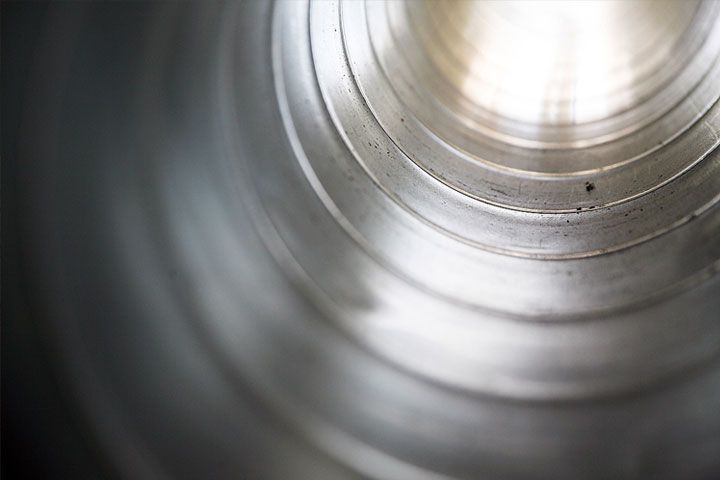 Un primer plano de un tubo de metal del que sale una luz.