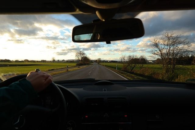 A person is driving a car down a country road