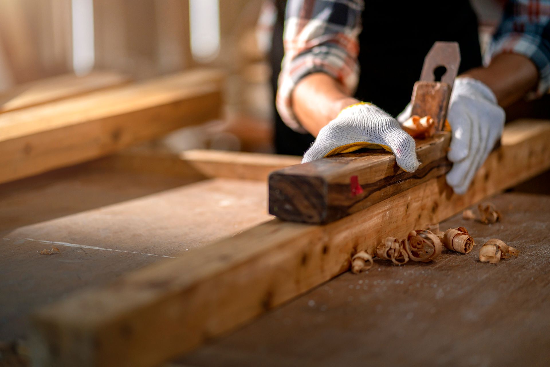 An electrician is working on a wall with a screwdriver.