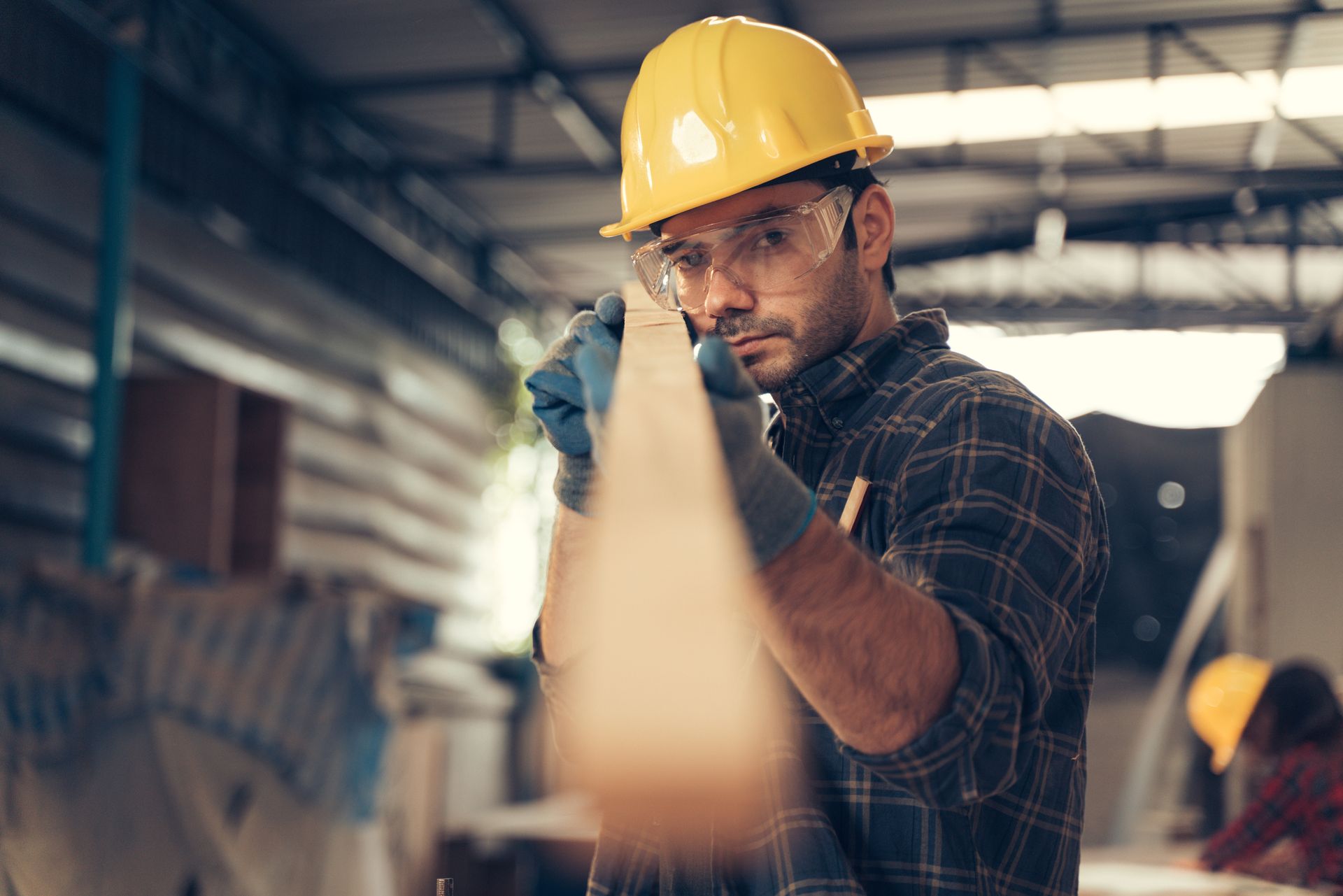 A man is standing on a ladder working on a ceiling fan.