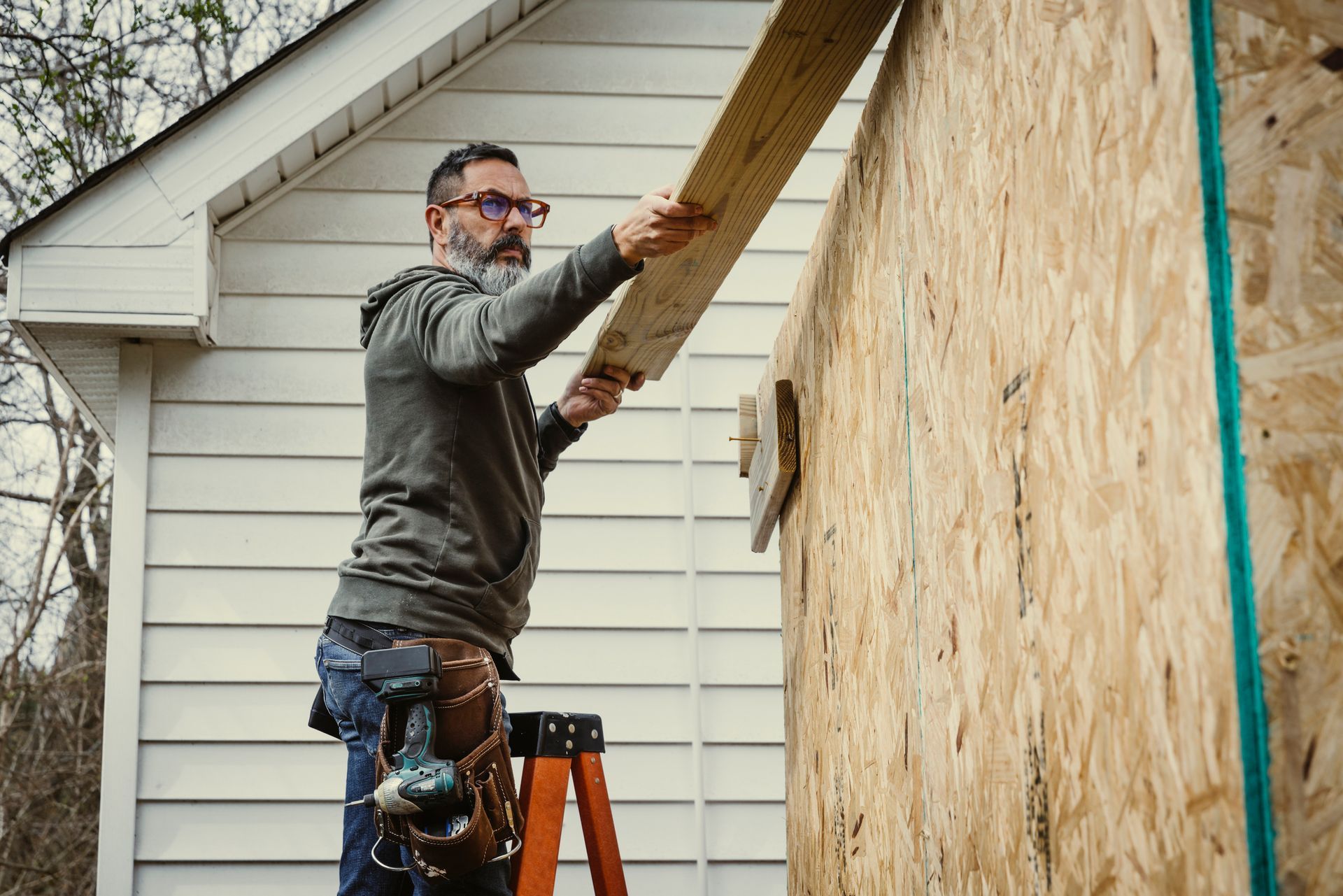 A man is holding a toolbox and shaking hands with a woman.